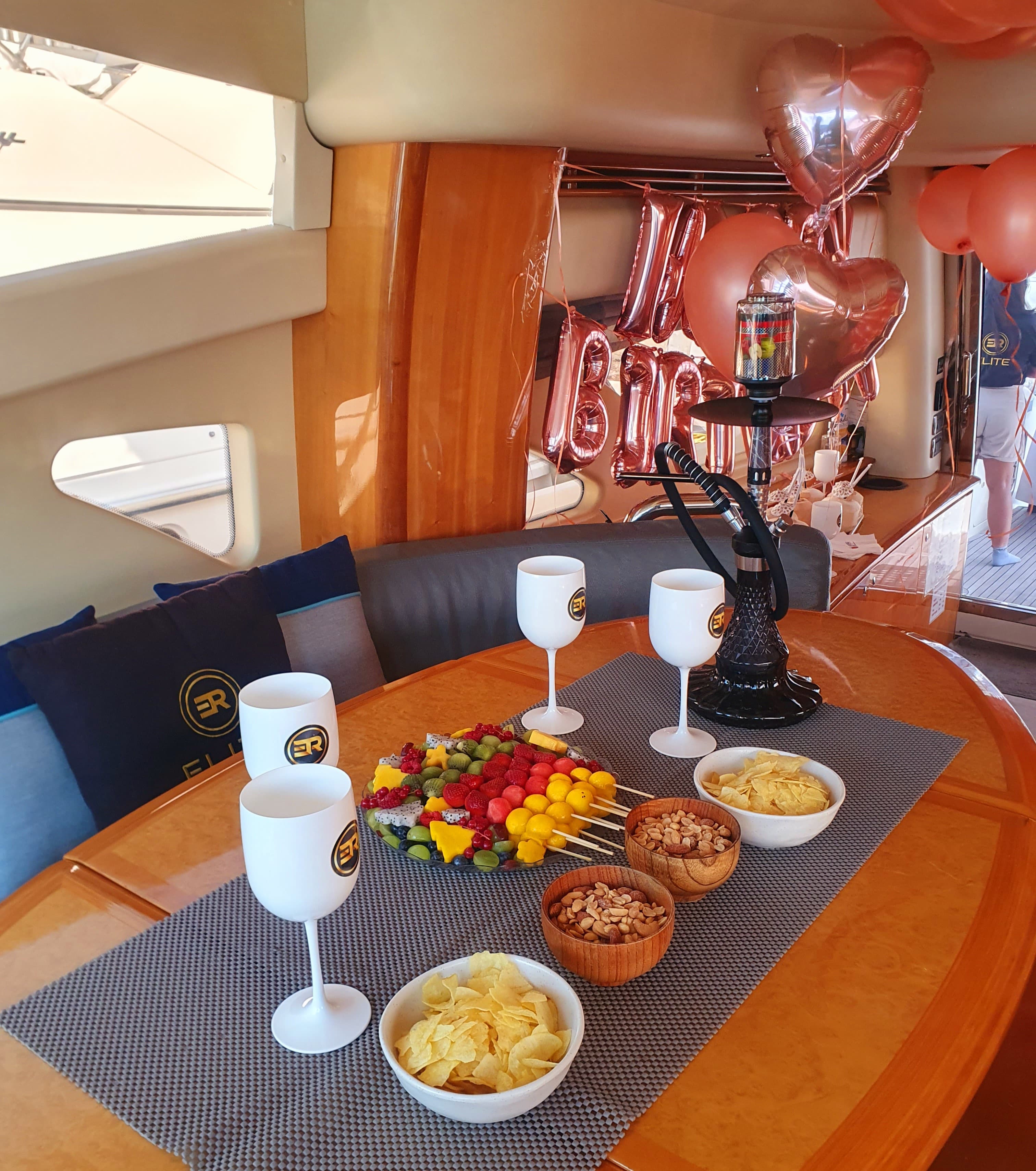 Yacht birthday celebration with balloons, fruit platters, and drinks onboard in Dubai